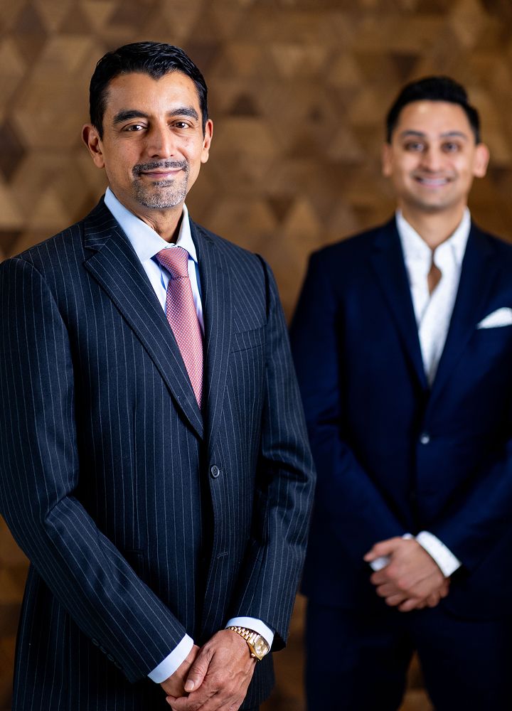 Two men in suits, smiling against a backdrop.