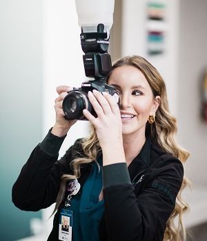 Nayak plastic surgery provider photographing with professional camera and flash.