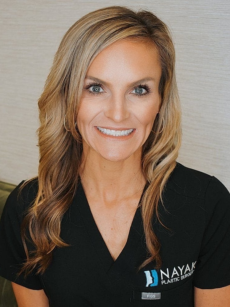 Female healthcare professional smiling in scrubs.