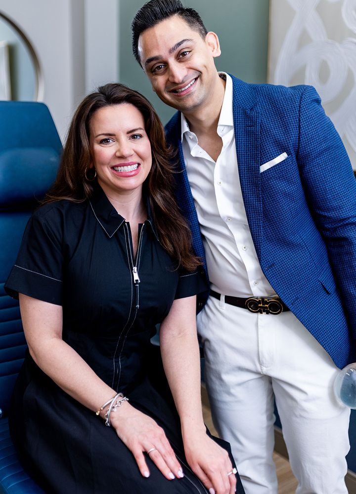 Two smiling professionals posing together indoors.
