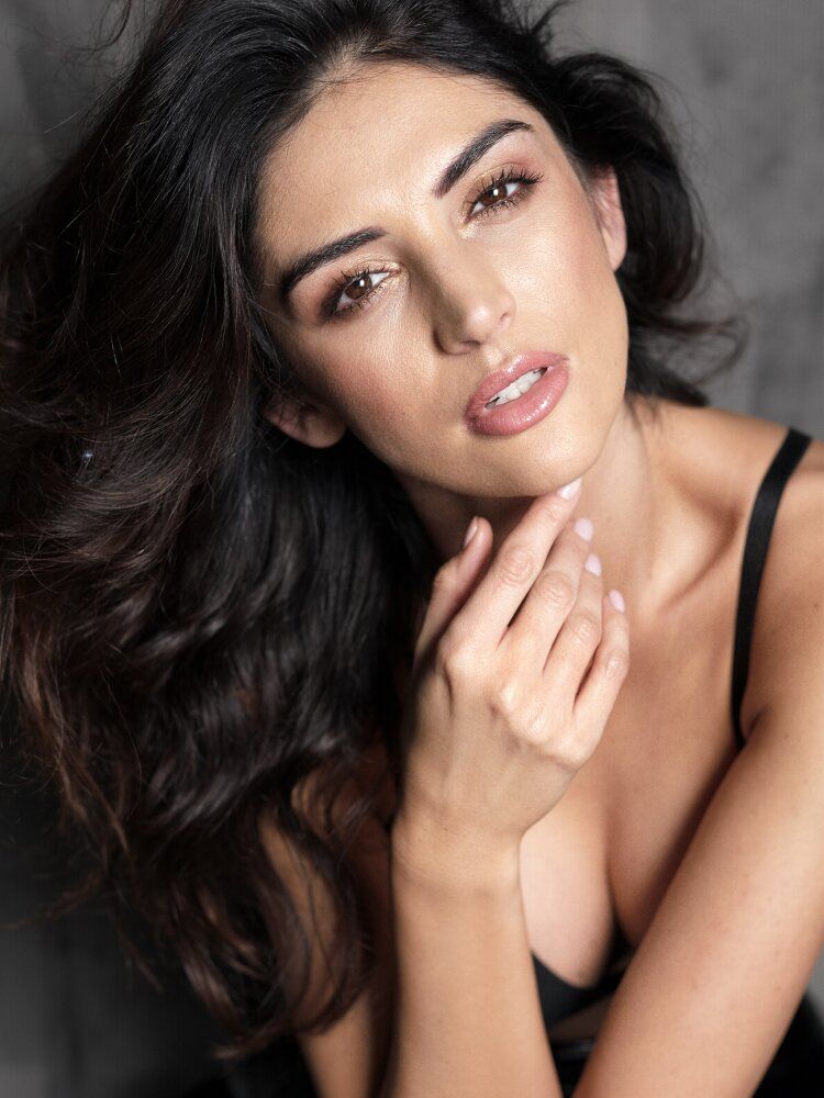 Woman with long hair posing thoughtfully.