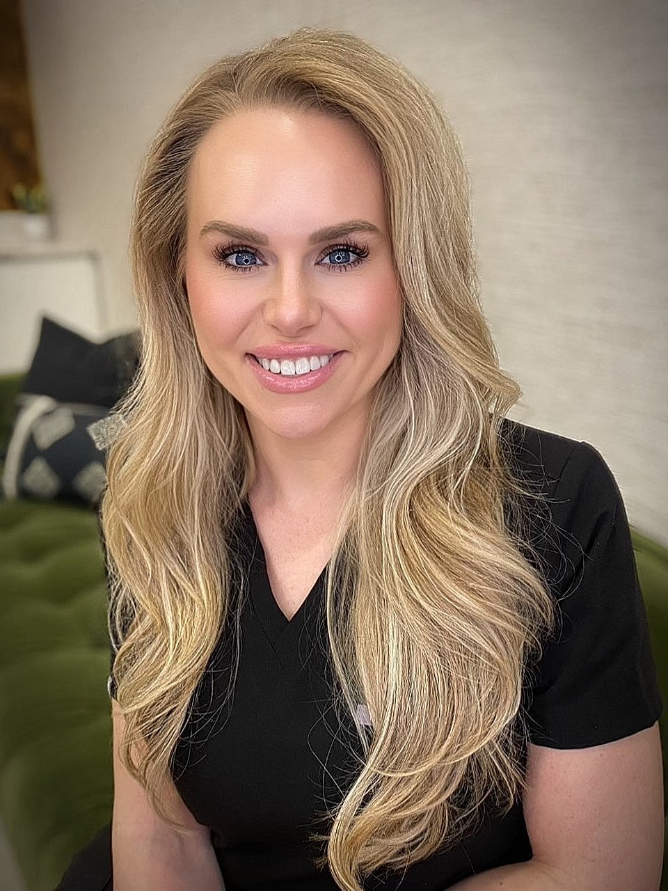 Smiling professional with long blonde hair.