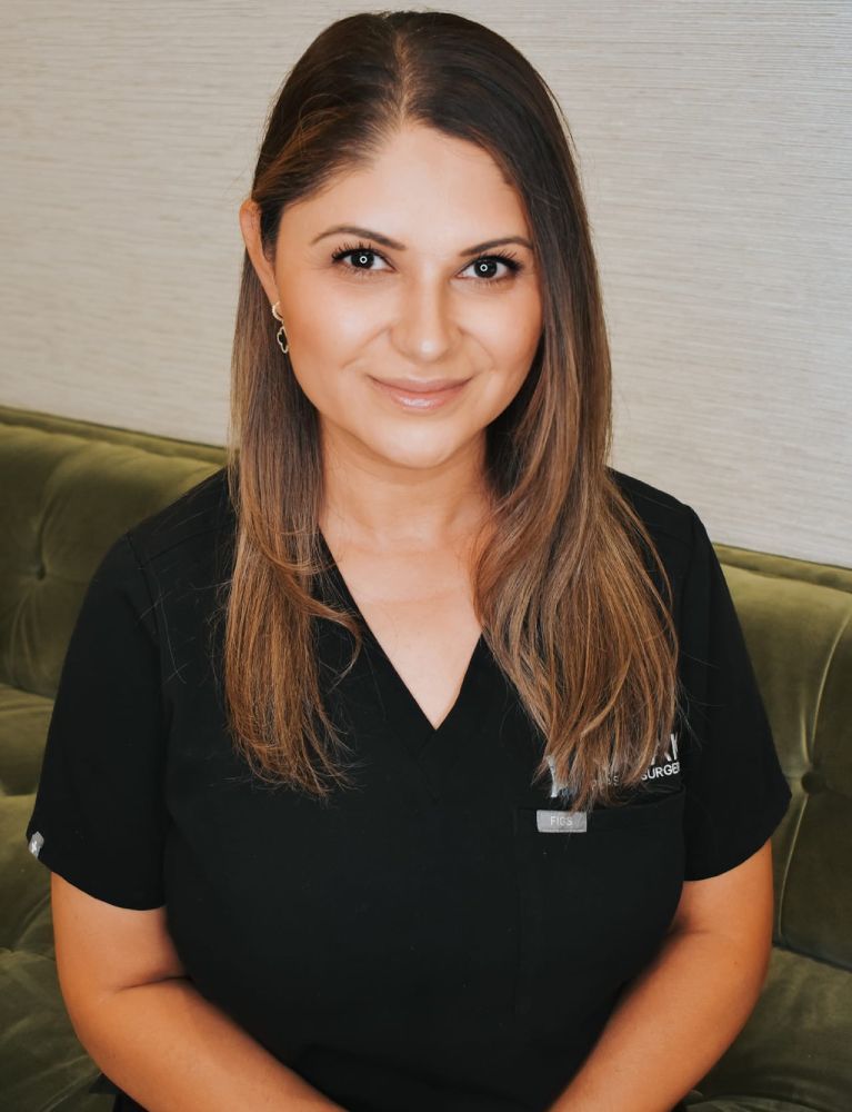 Female doctor smiling in scrubs portrait.