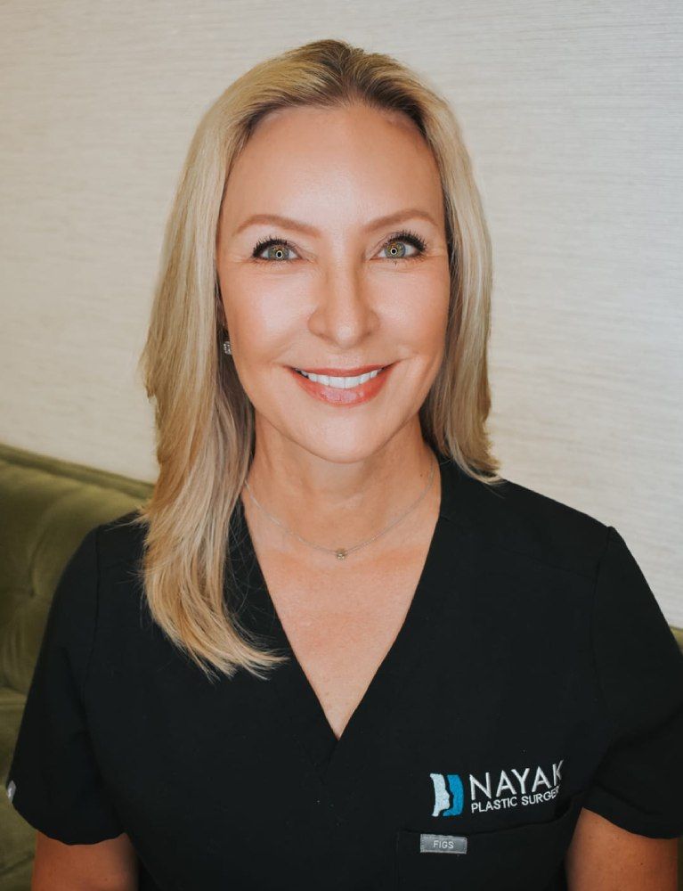 Female plastic surgeon smiling in professional attire.