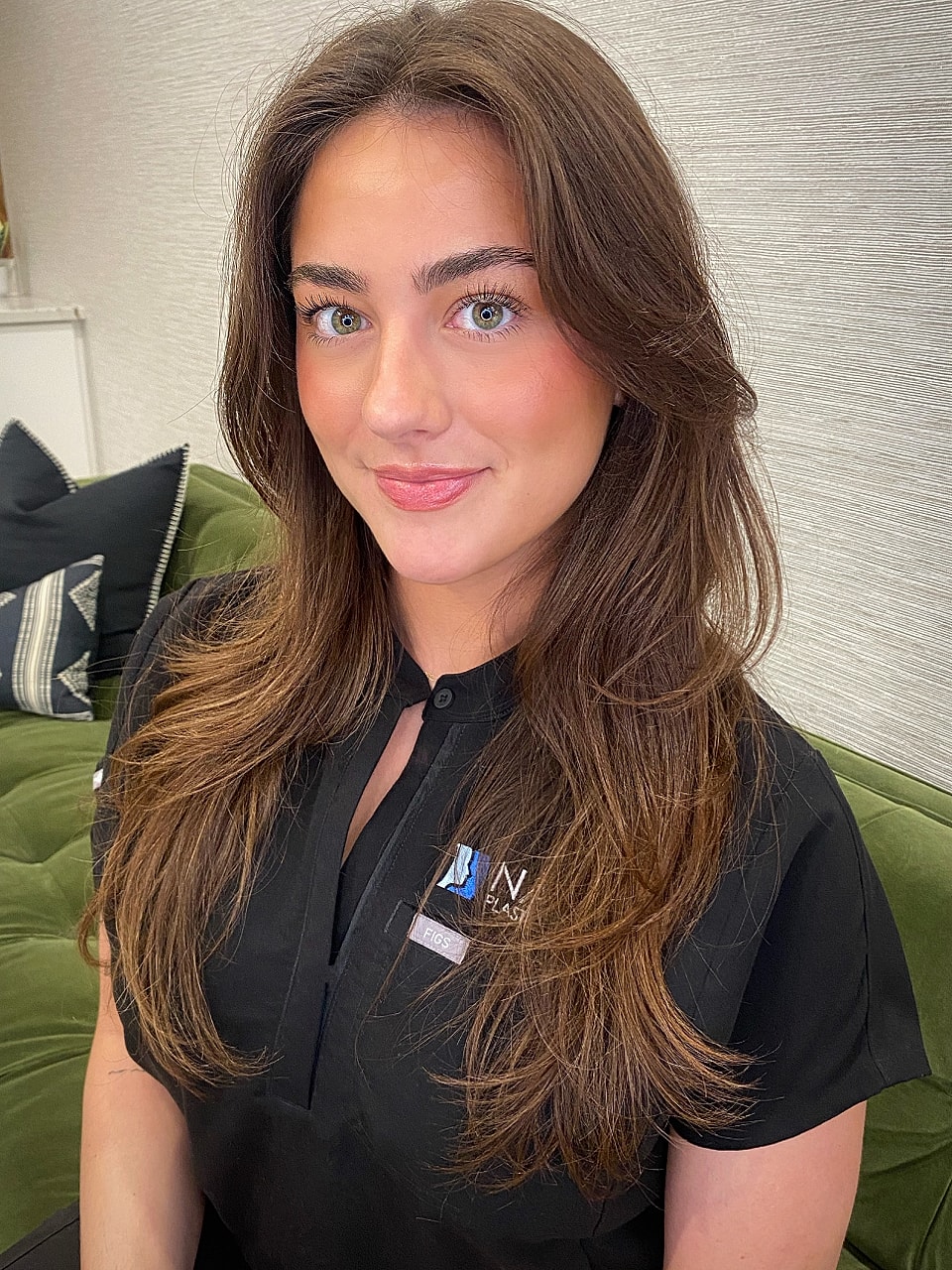 Person in black shirt with natural makeup and hair.