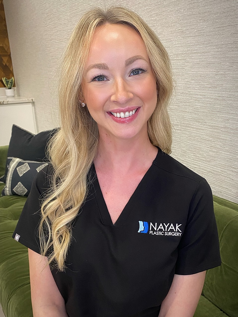 Smiling professional in medical attire, plastic surgery.