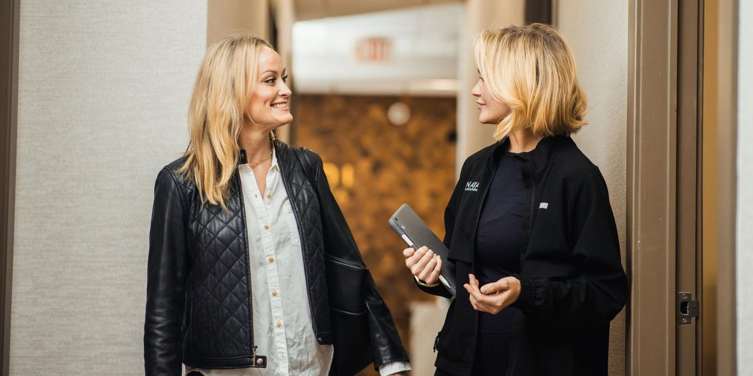 Two women chatting in a hallway.