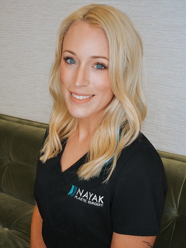 Blonde woman in plastic surgery clinic attire.