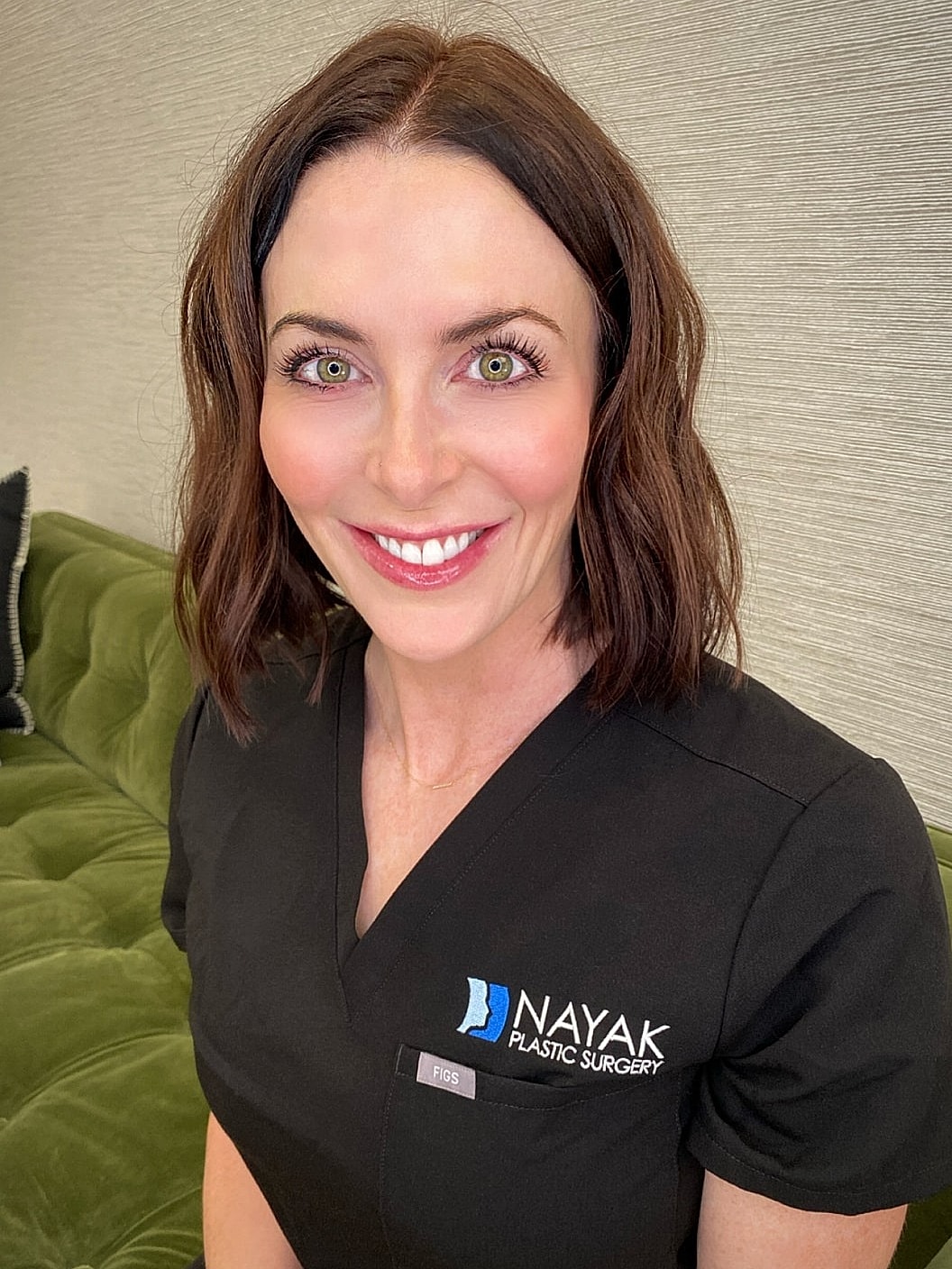 Sarah S in scrubs smiling at camera.