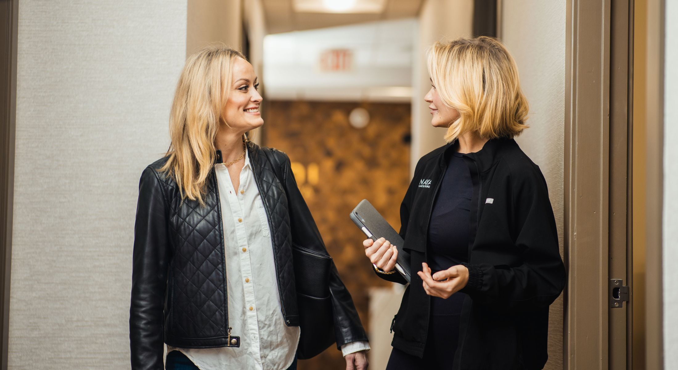 Two women chatting in a hallway.