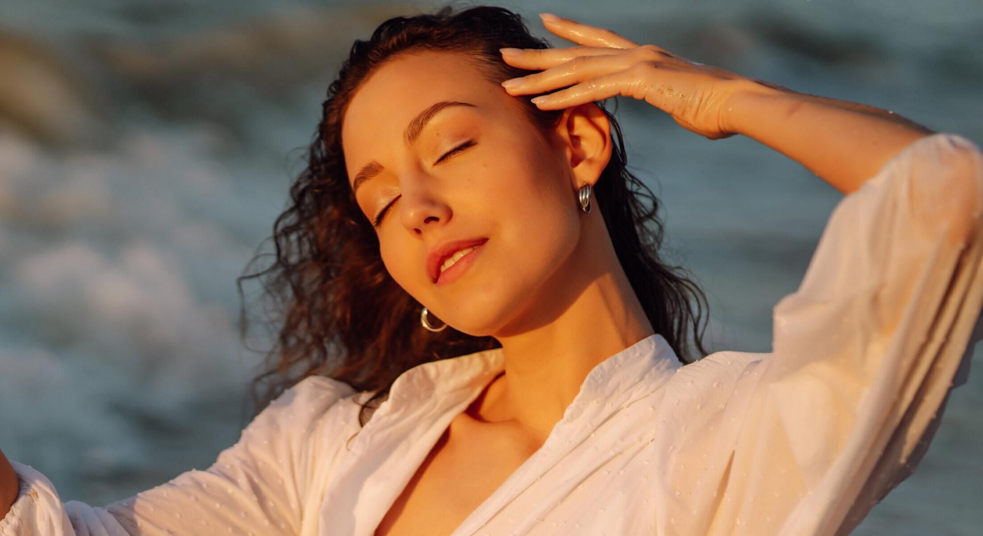 Woman enjoying the beach sunset, relaxed and happy.