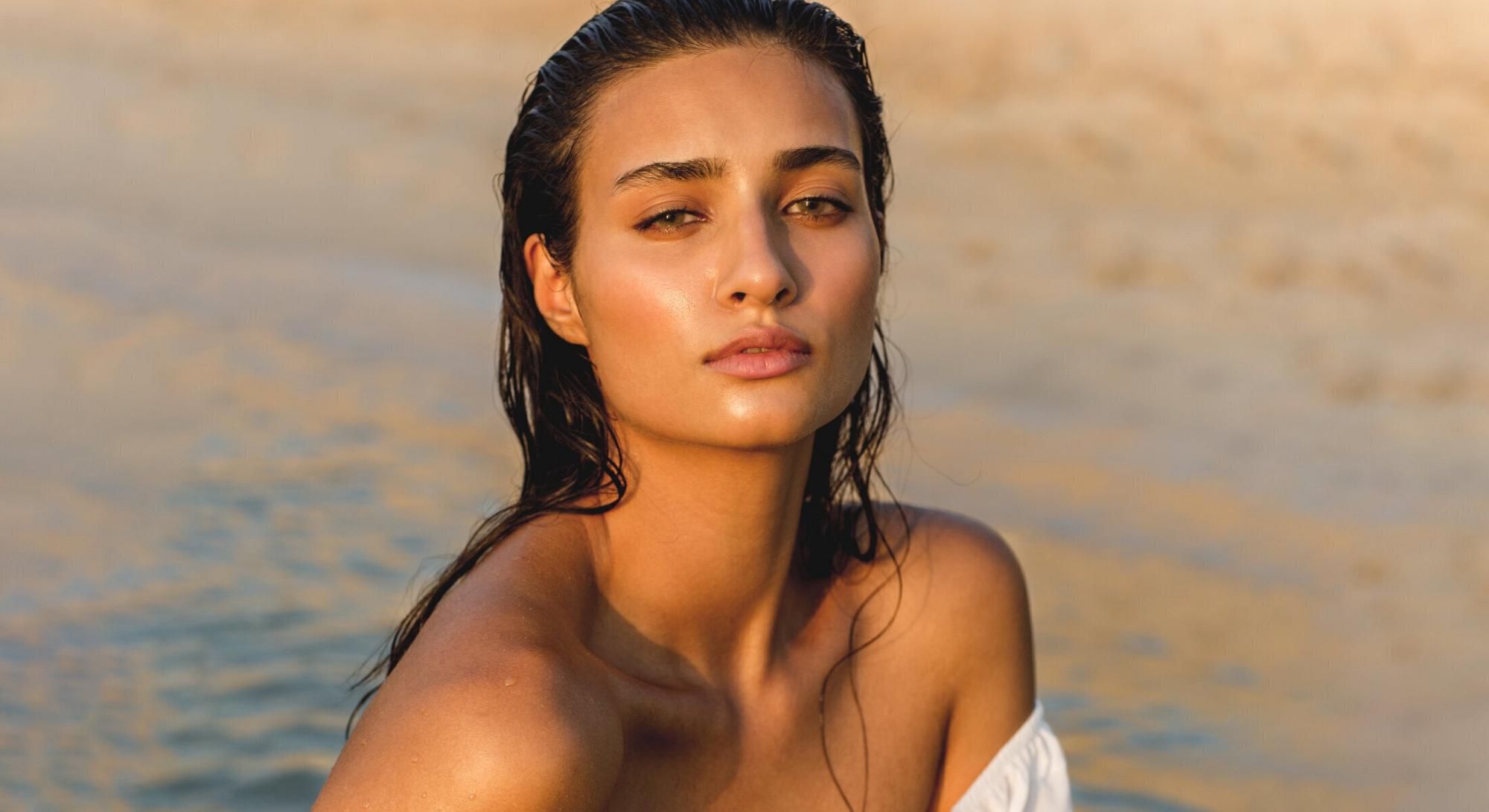 Woman with wet hair near the water.