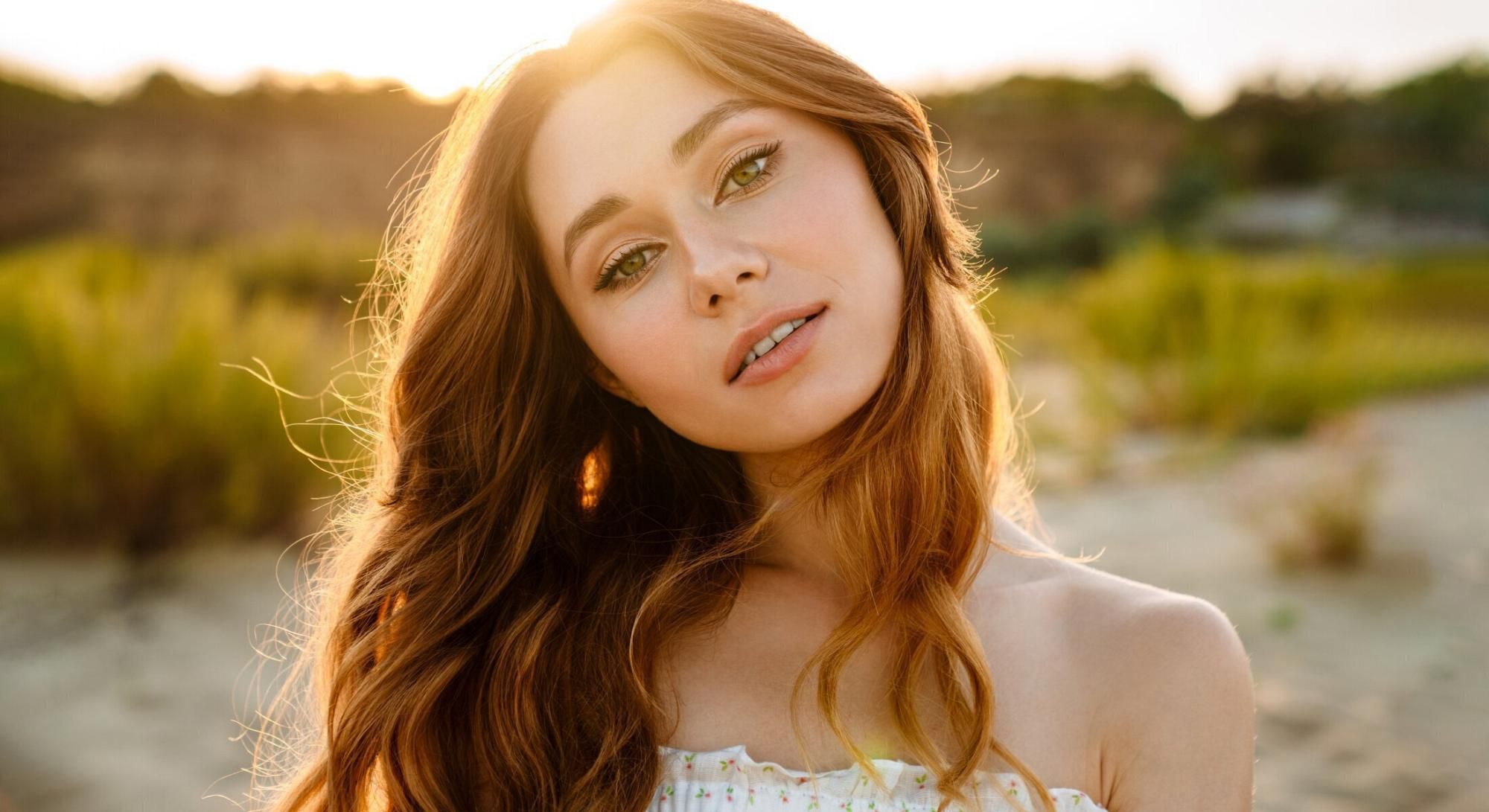 Young woman with flowing hair in sunset light.