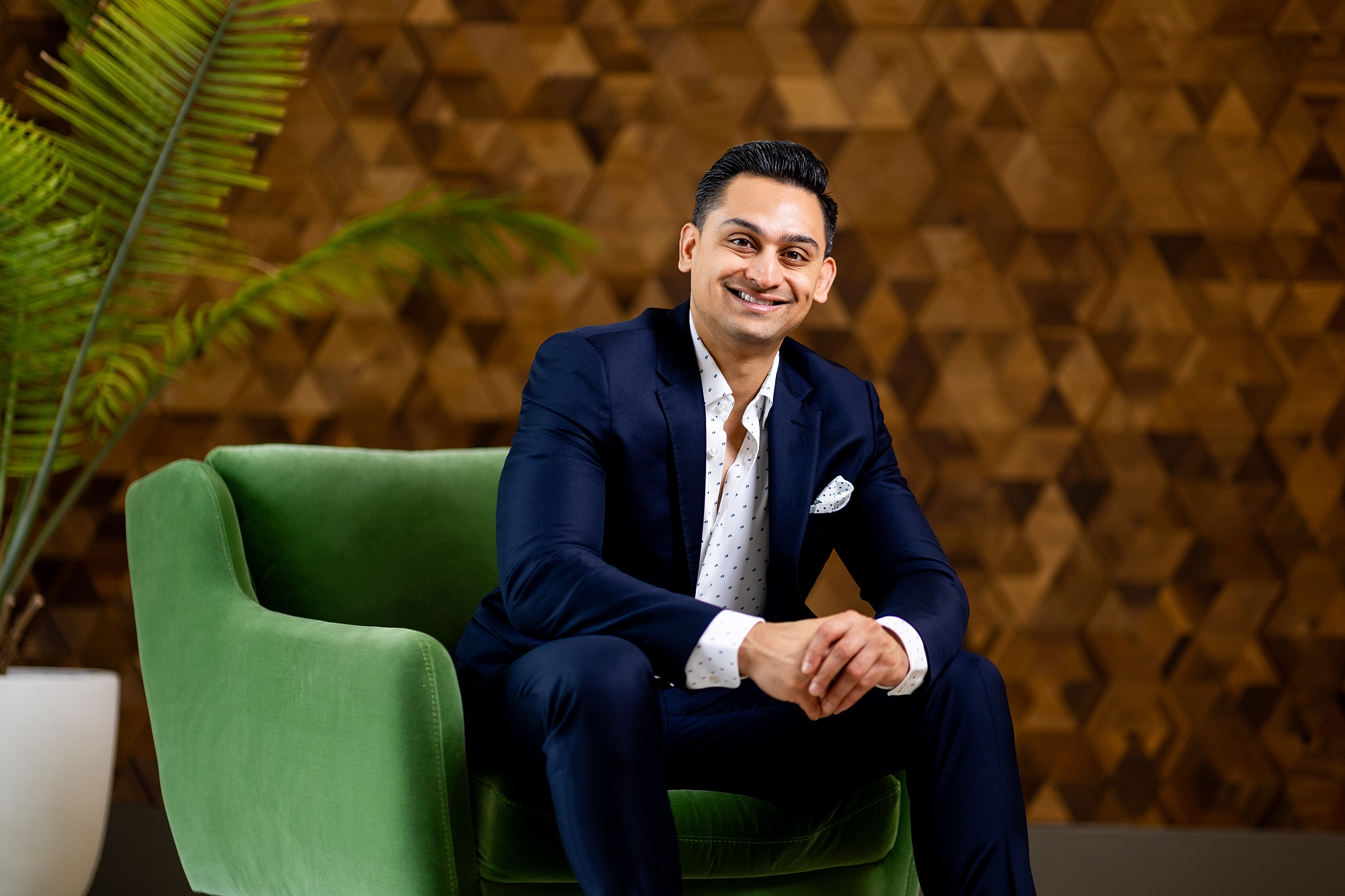 Modern waiting area with green sofas and decor.