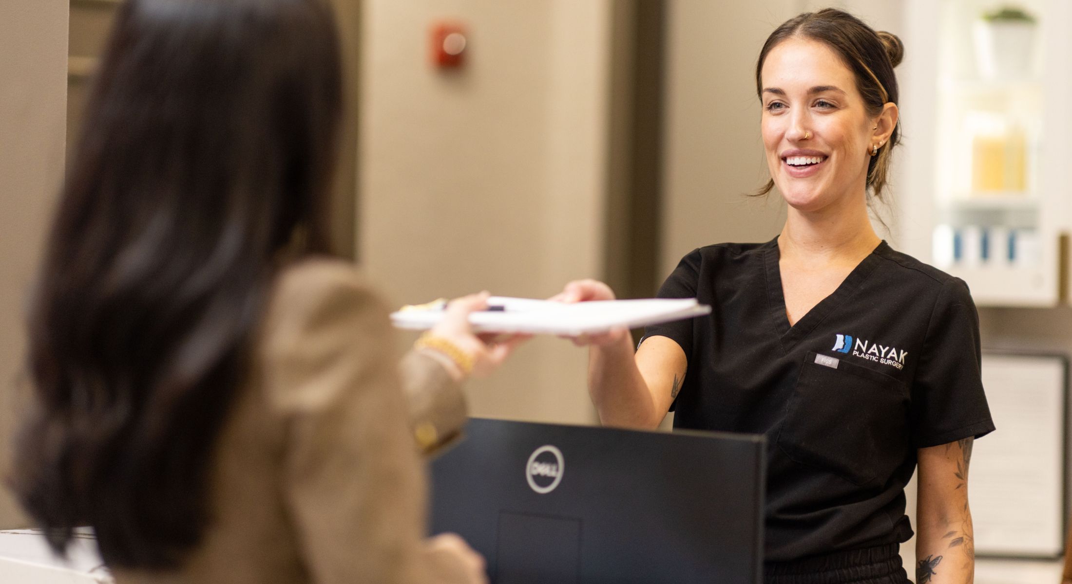 Receptionist assisting a client with paperwork.