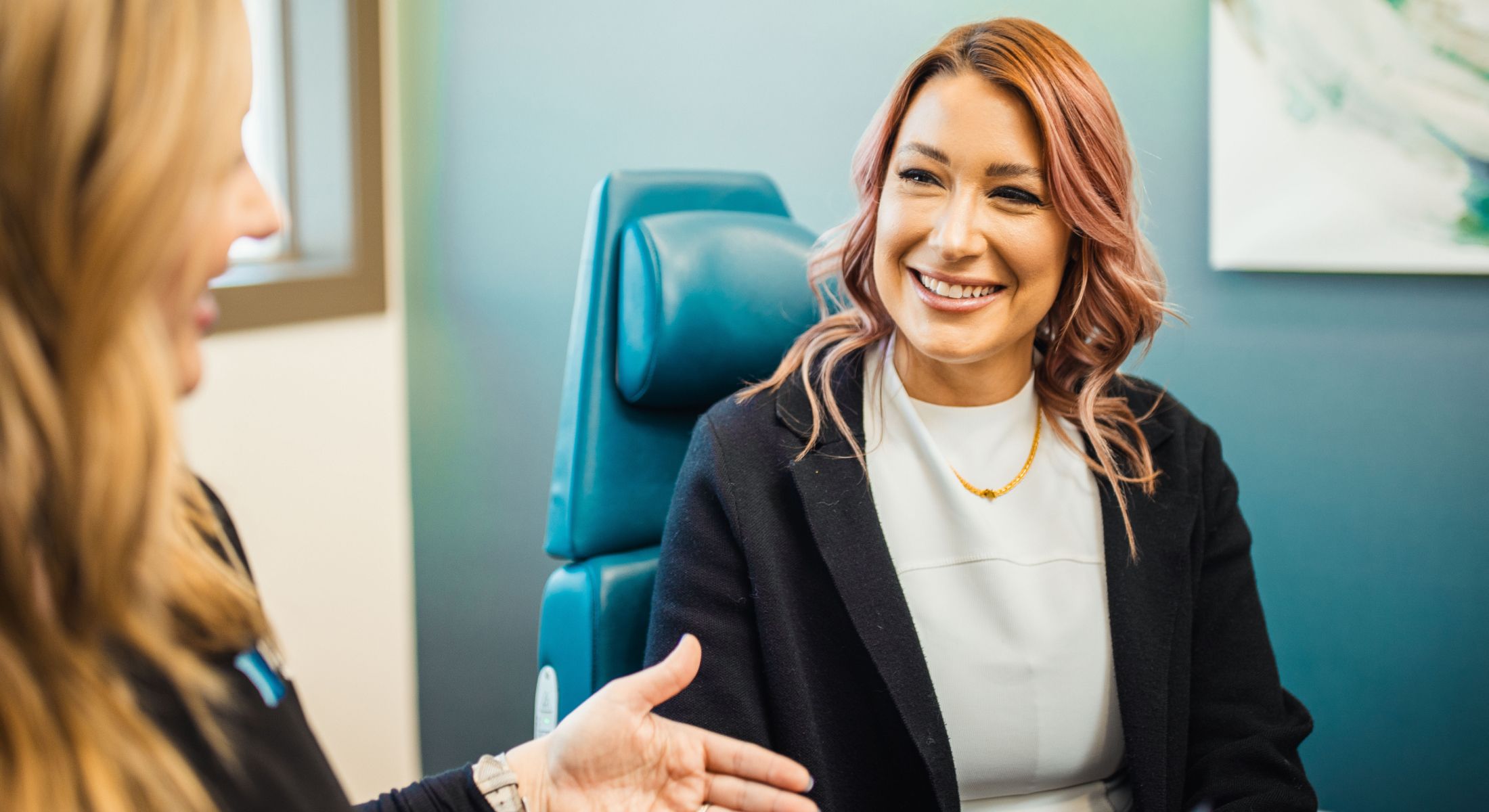 Women engaged in conversation in a professional setting.