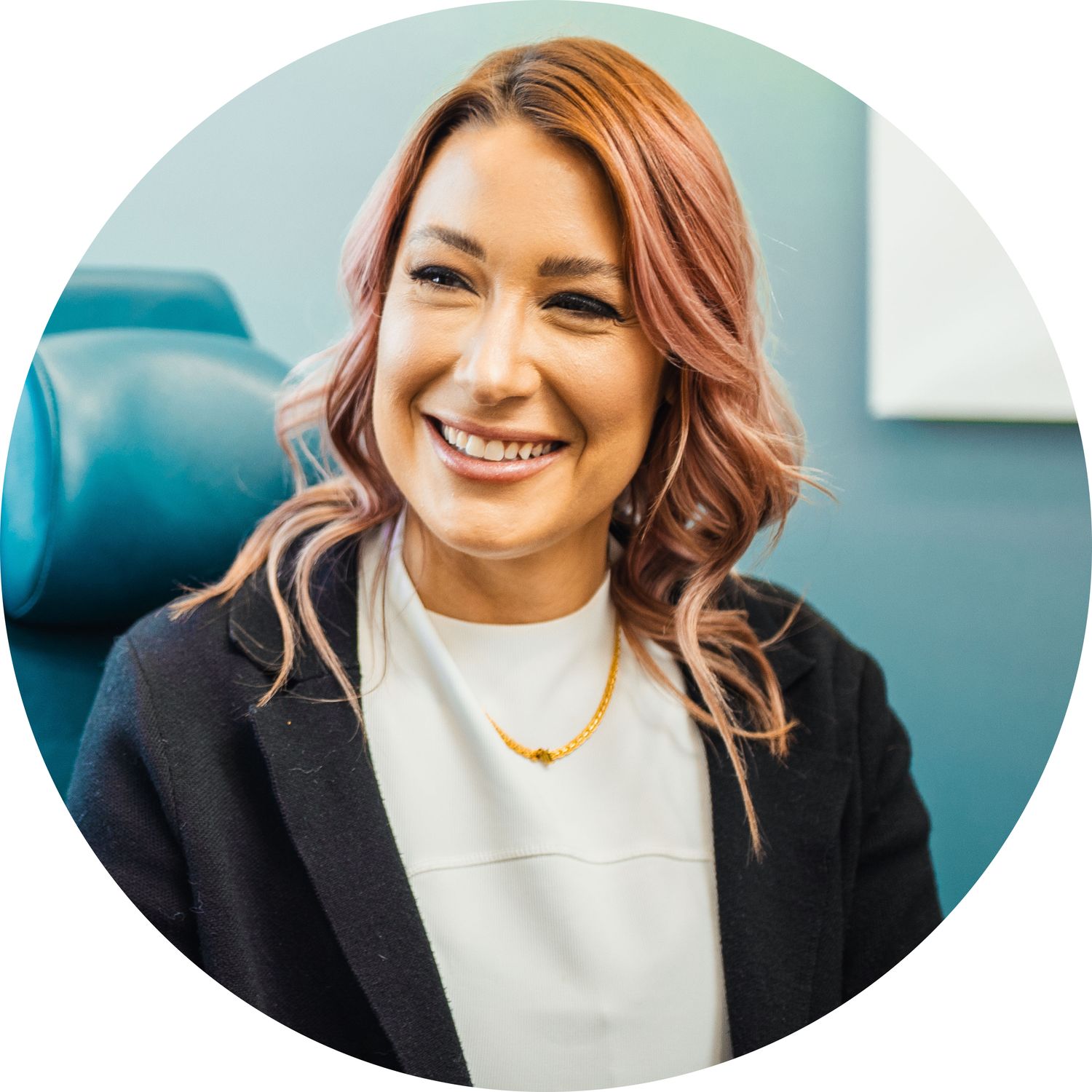 Smiling woman with pink hair in professional setting.