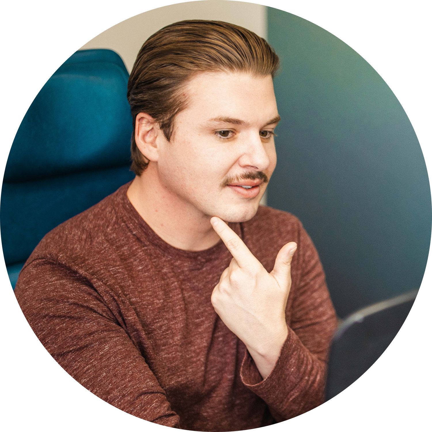 Man pondering while sitting at desk.