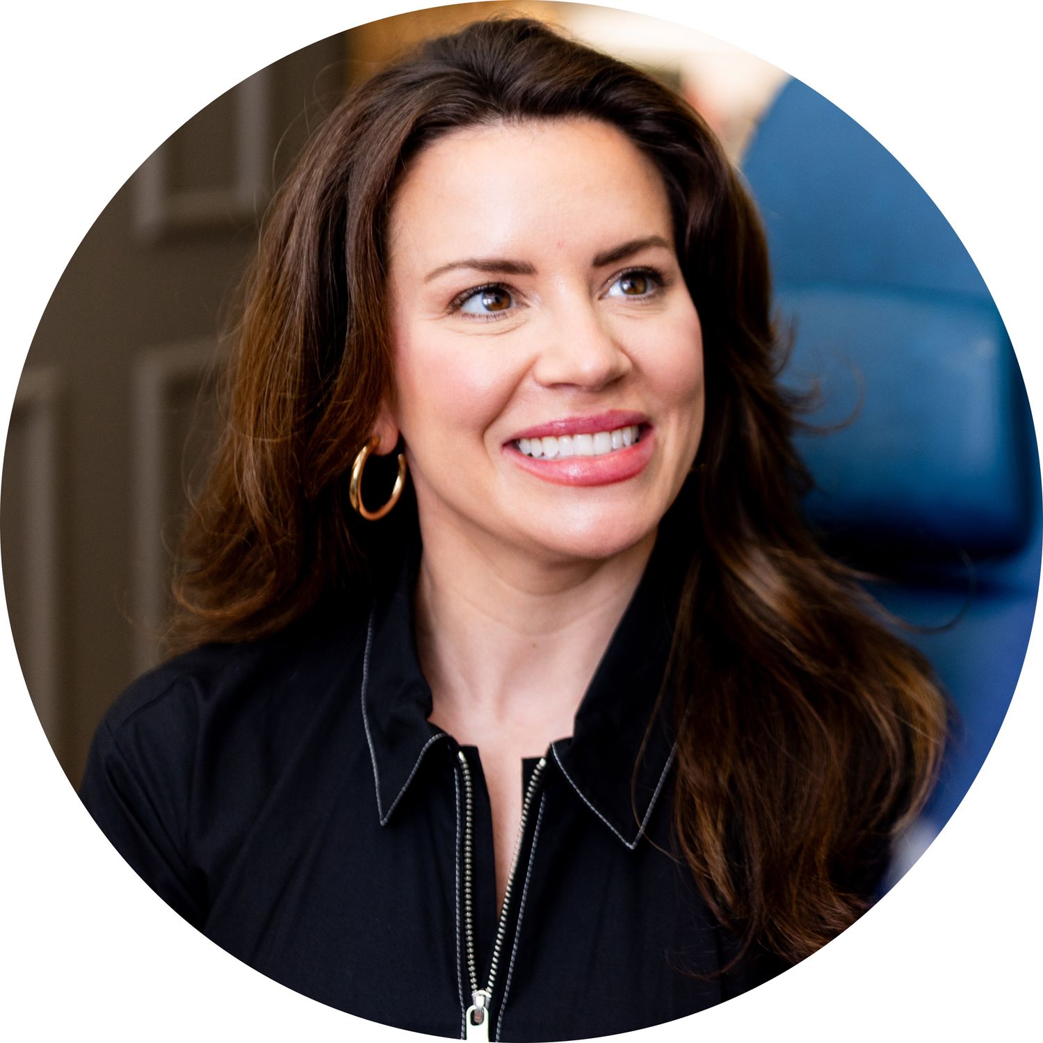 Smiling woman with long hair and earrings.