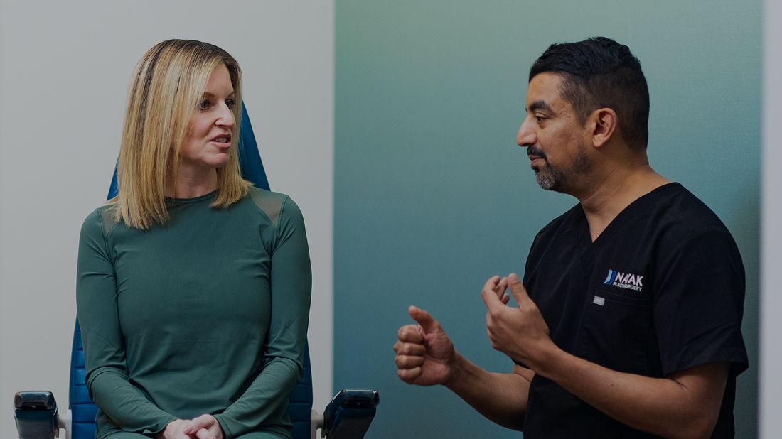 St. Louis facial plastic surgery provider, Dr. Nayak consulting with patient in medical office.